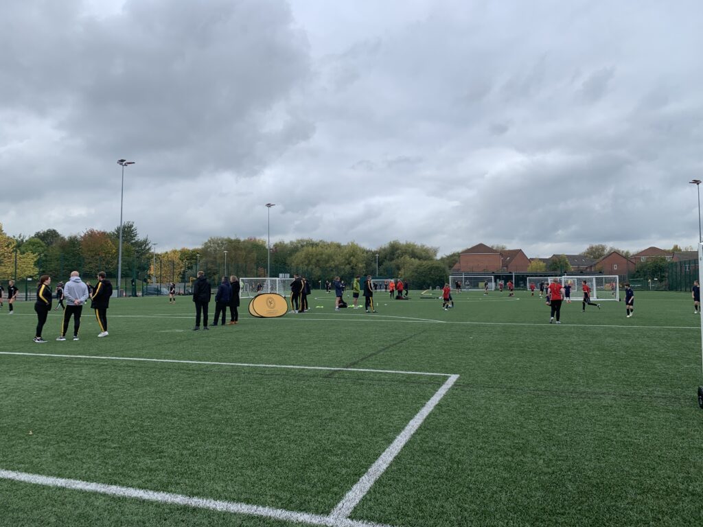 Group of children playing football on an astro turf pitch