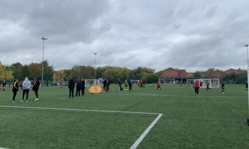Group of children playing football on an astro turf pitch