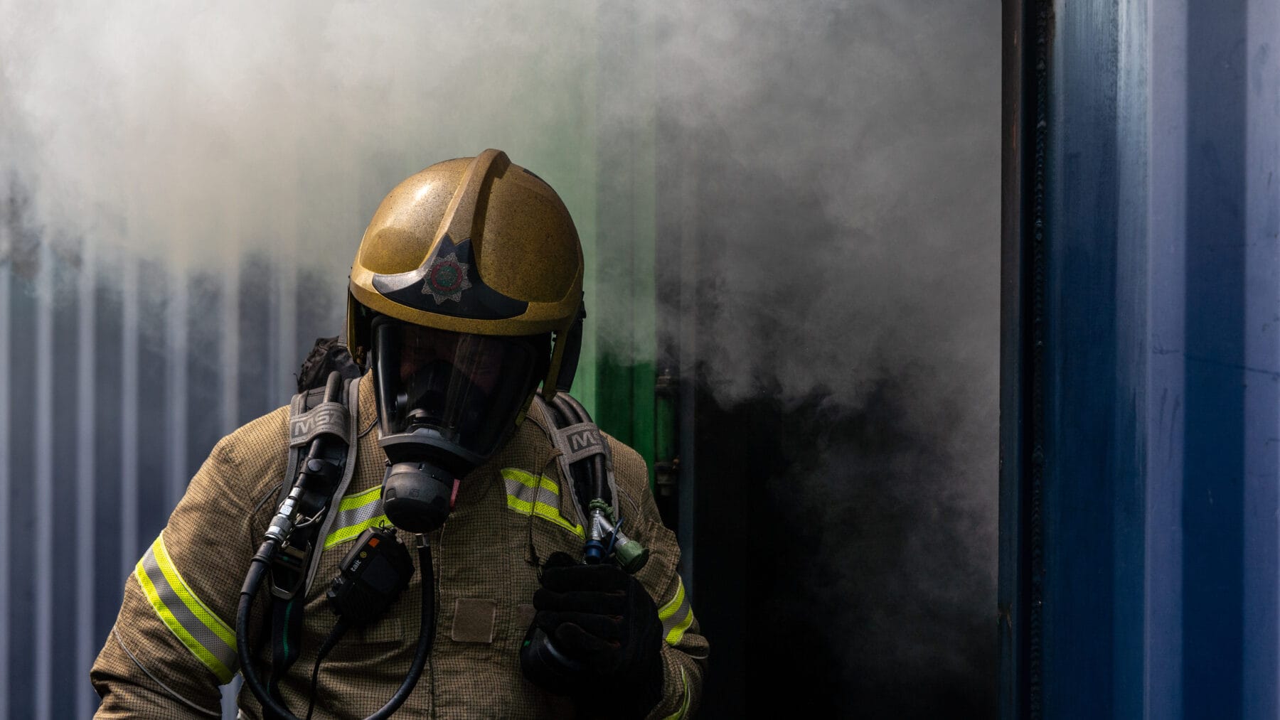 Firefighter in kit walking through smoke