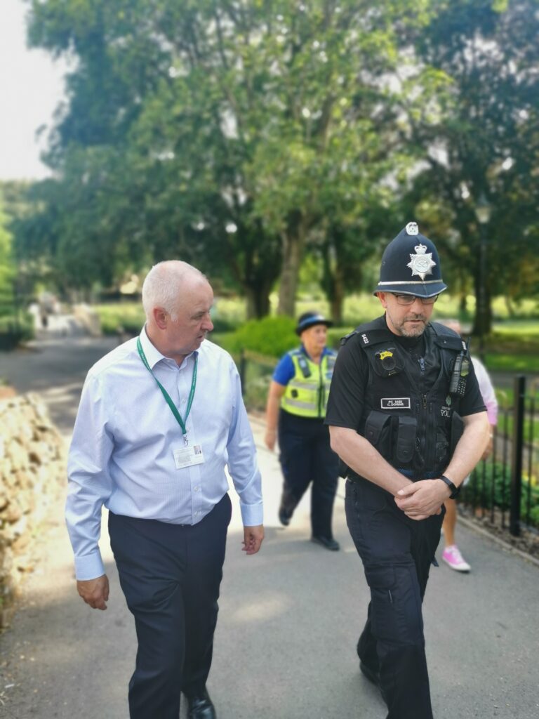 Ben walking in a park with a police officer