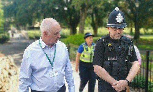 Ben walking in a park with a police officer