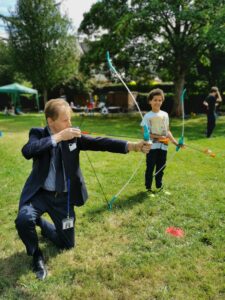 Matthew Ellis with young person playing archery